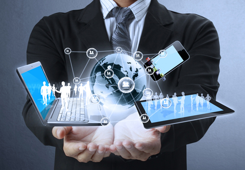 A businessman with his arms outstretched, showing a number of electronic devices.