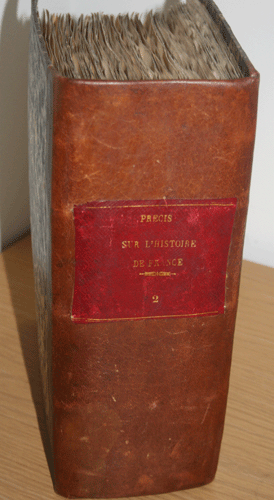 This image shows the predominantly brown leather spine of Precis Sur L'Histoire De France [A Brief History of France]