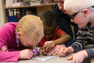 kids in classroom using tactile map and braille