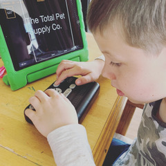 Young boy using braille display.