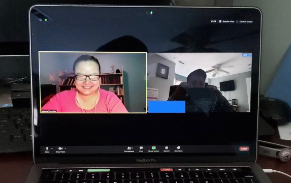 A laptop screen showing two people participating in a video meeting.