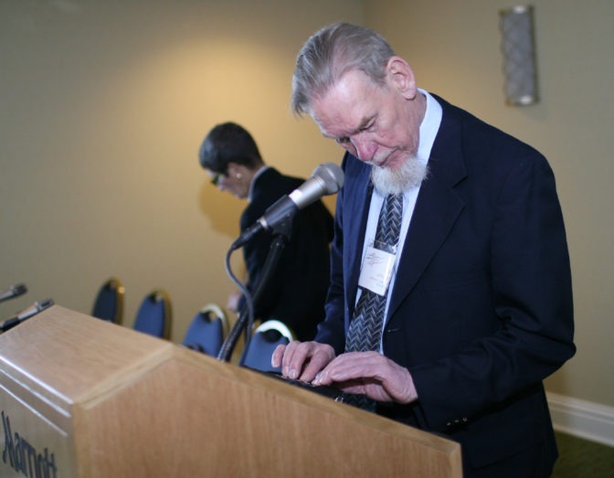 Gil Johnson prepares for a speech at a podium.