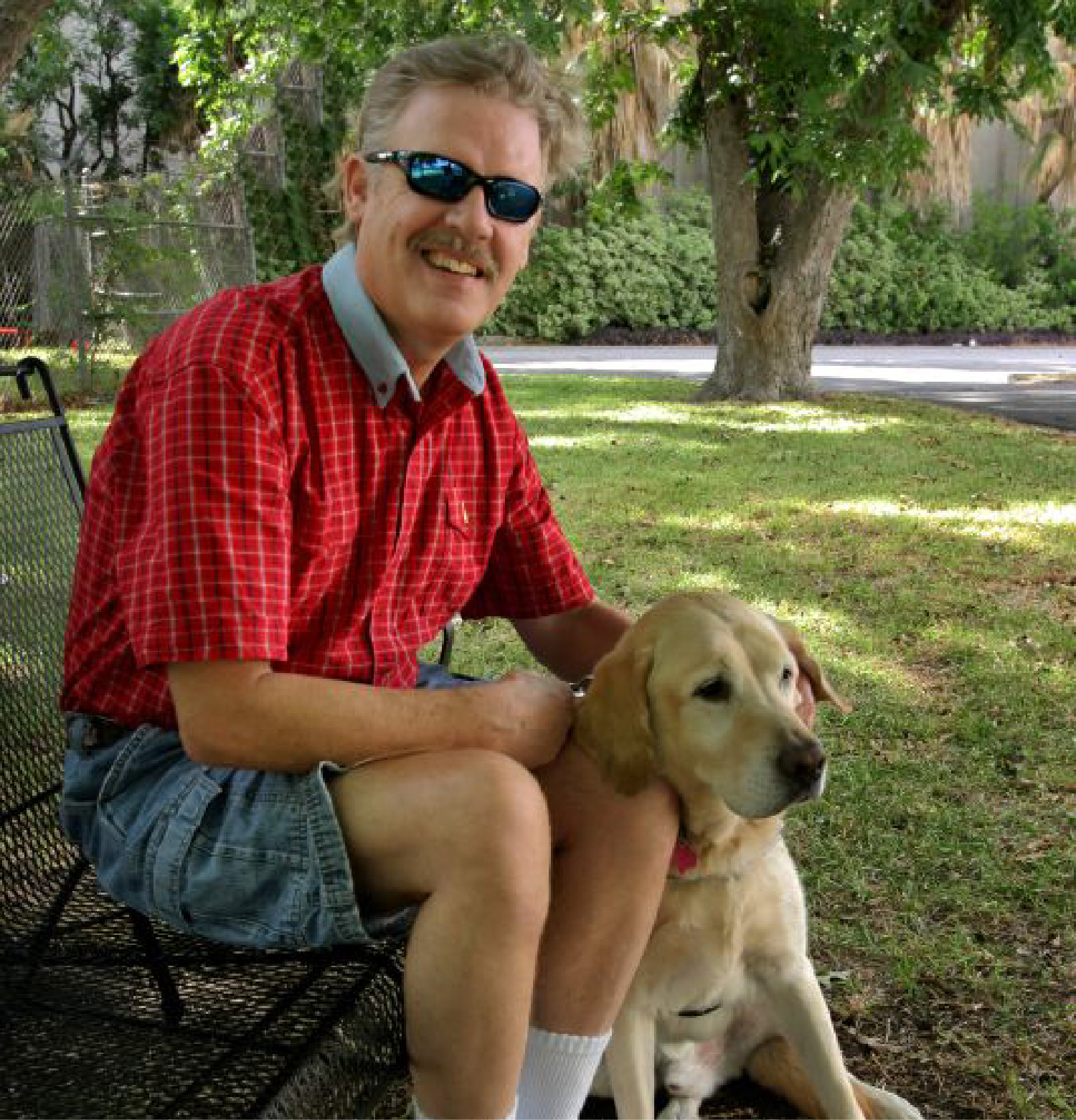 A man at the park with his guide dog.