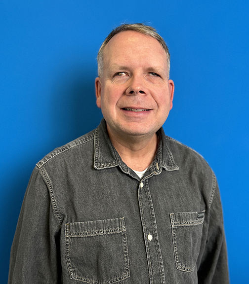 A smiling man with short salt-and-pepper brown hair. 