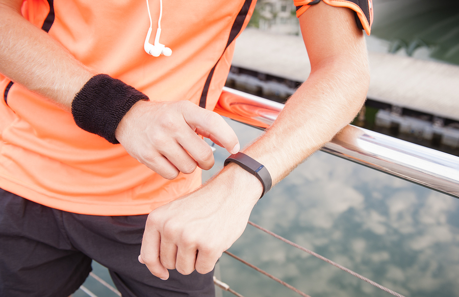 Man reading Fitbit on his wrist as he exercises