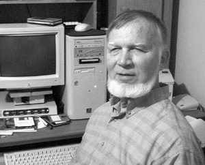 Figure 1: Photograph of Bud Keith in front of computer equipment.