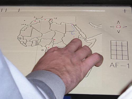 Close-up view of a hand touching a tactile map of Africa.