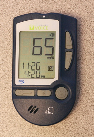 The Prodigy Voice showing a blood glucose reading and the date and time.