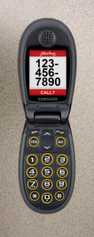 Photo of the Jitterbug J, open on a table, displaying a phone number in large font.