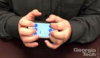 A photo of BrailleTouch being used on a smartphone