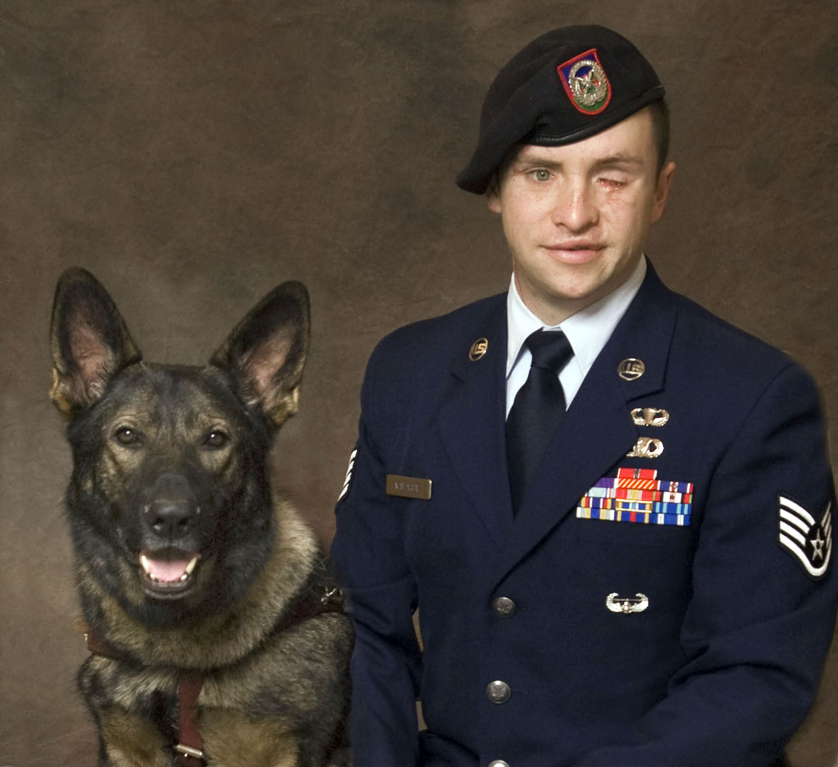 Photo of Mike Malarsie in uniform with dog guide at his left.