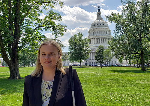 in the foreground, Stacy Cervenka in the lawun outside the US Capitol building. The domed front of the capitol building is in the background.