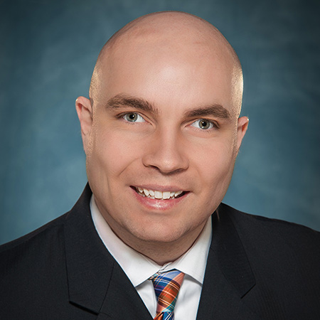 A close-up headshot of Russel Shaffer. He is a clean-shaven white male with a smile on his face. Russell is wearing a