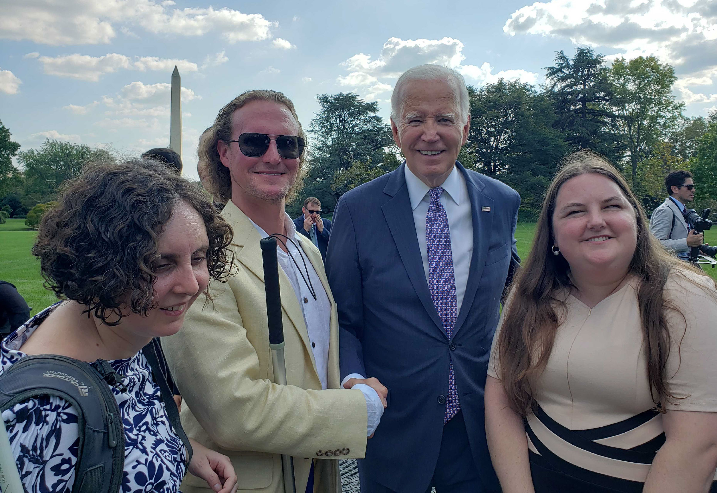 Dr. Arielle Silverman with President Biden and other accessibility advocates in front of Washington monument.